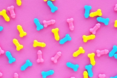 Background of multicolored candy on a pink background. Copy space.