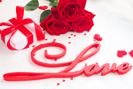 inscription love, roses, gift box, hearts on a white background. copy space.の写真素材