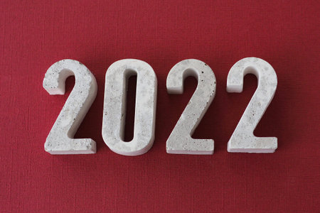concrete numbers 2022 on burgundy background.の写真素材