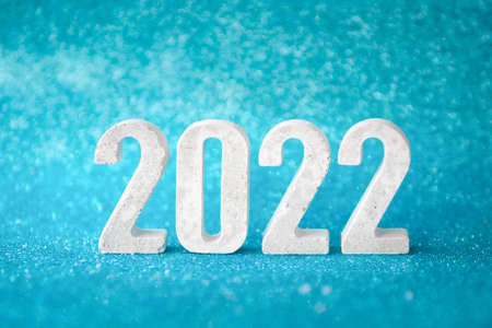 Concrete numbers 2022 on blue glittering background. copy space.の写真素材