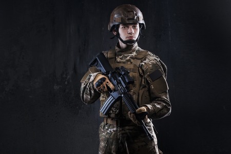 Special forces soldier with rifle on dark background. Ammunition Soldier.の写真素材