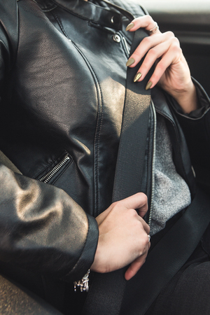 Cropped image of girl fastening a seat belt while driving a carの写真素材