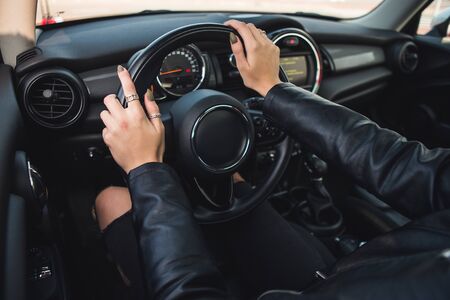 Cropped image of girl driving a car, hands on steering wheelの写真素材
