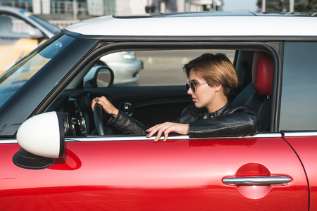 Portrait of smiling businesswoman driving her car.の写真素材