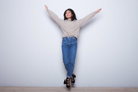 Happy emotions. Young beautiful smiling girl have a fun and dancing near white isolate background....