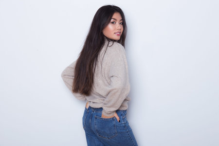 Beautiful and sexy attractive girl in a sexy jeans posing isolated on white background. Sexy Asian...