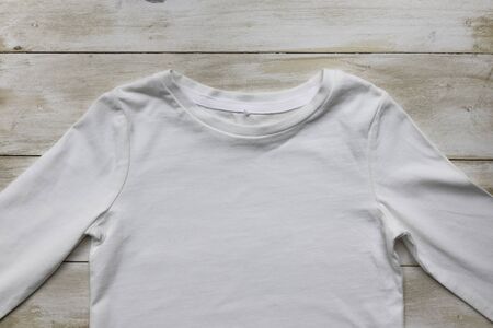 Plain white gender neutral Toddler tshirt on light wooden surface - mockupの写真素材