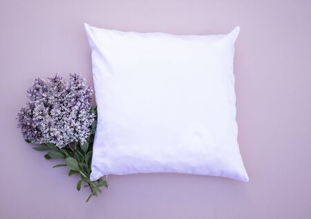 Blank white square cushion on pink background with lilac flowers mock up onの写真素材