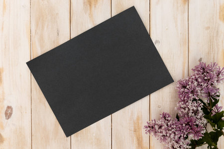 Blank black a4 quote sign on white washed wood background with lilac flower props, quote block wood...