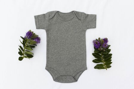 Grey Baby Bodysuit Mockup On a White Background With Purple NZ Flowers - Styled Floral/Spring Baby Bodysuit Stock Photo With Flowersの写真素材