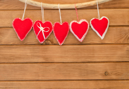 Romantic love composition of red felt hearts on wooden backgroundの写真素材