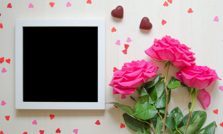 St Valentine's Day empty mock up with pink roses, paper hearts and white photo frameの写真素材
