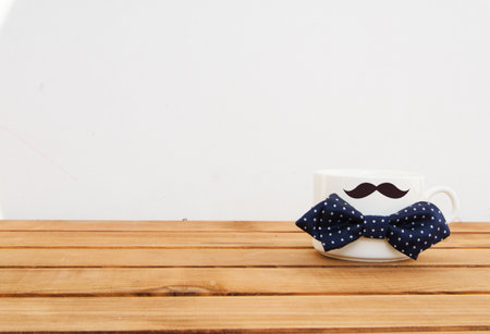 White mug on wooden background with mustaches and hand drawn lettering. Father's Day funny greeting card conceptの写真素材