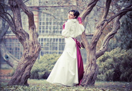 Beautiful bride in wedding dress nearly treeの写真素材