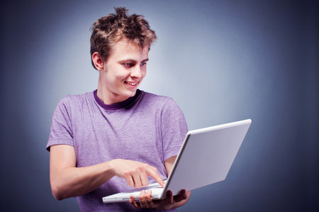 Studio shot of a young man using laptopの写真素材