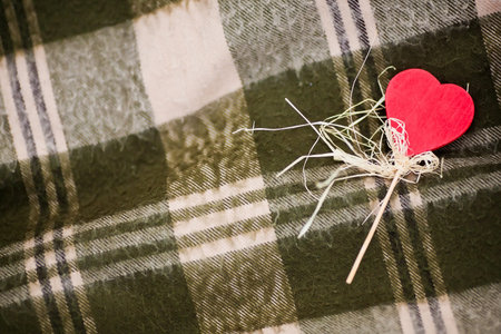 Red heart-shaped candy on the checked plaid