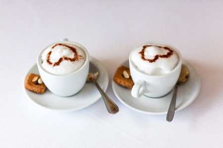 cups of cappuccino with foam in the form of heartの写真素材