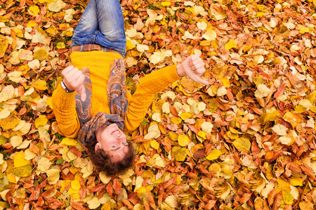 man with curly hair in autumnの写真素材