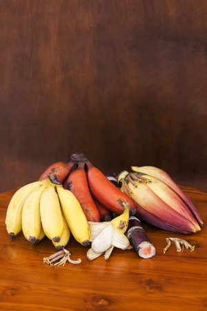 bananas with banana flower and sugar reed stick on wooden backgroundの写真素材