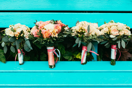 bride and bridesmaids Wedding bouquets with roses and other flowers on turquoise benchの写真素材