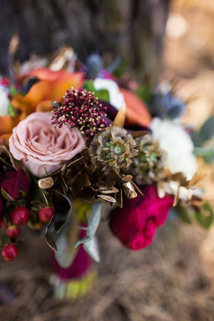 roses and other flowers inside marsala rustic wedding bouquetの写真素材