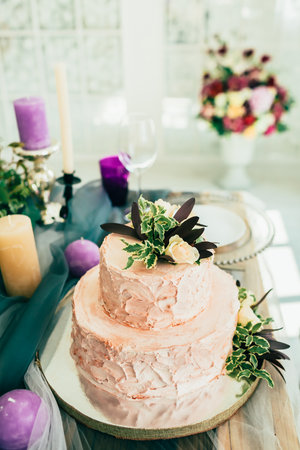 Beautiful wedding cake with flowers on  wooden table with ?andleの写真素材