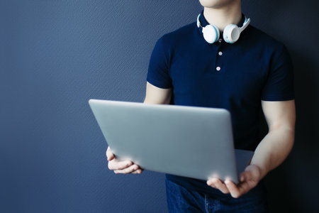Young athletic man in t-shirt with headphones and laptop.の写真素材