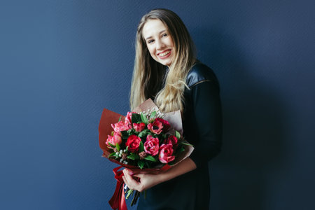 Cute girl with bouquet of red tulips.の写真素材