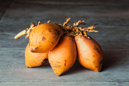 Bunch of ripe scratched orange mangoes on wooden floor. Close-upの写真素材