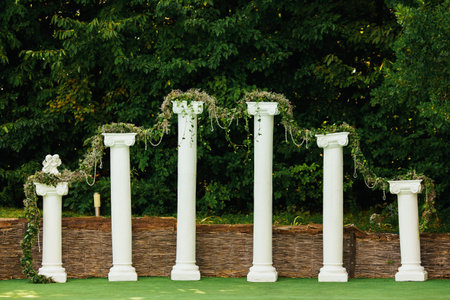 Decorated columns ahead of treesの写真素材