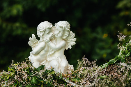 Sculpture of two angels on flowers garlandの写真素材