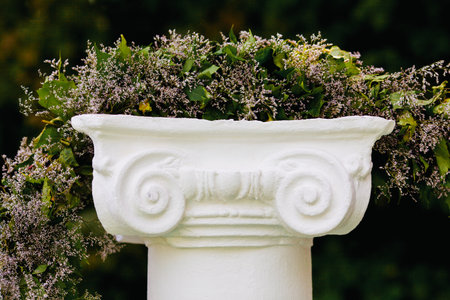 Beautiful flower garland on stone pedestalの写真素材