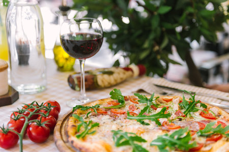 Pizza with glass of wine, on served tableの写真素材