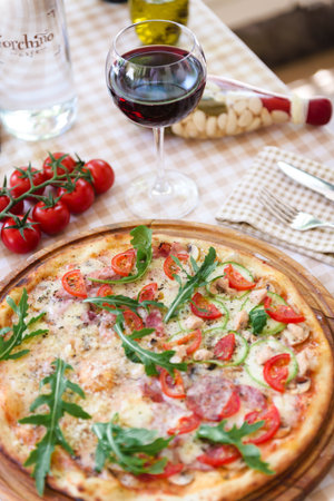 Pizza with glass of wine, on served tableの写真素材