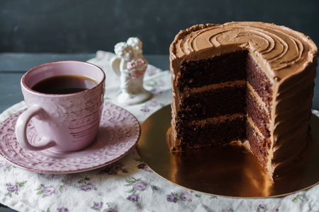 Delicious cake in chocolate sauce with cup of tee