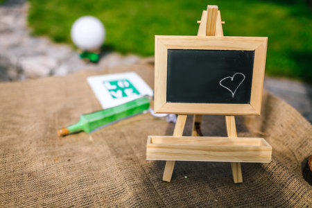 Blank chalkboard with wooden tripod in wedding ceremony with outdoor and garden styleの写真素材
