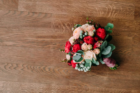 Wedding bouquet of red and cream roses on a wooden floor. Top viewの写真素材