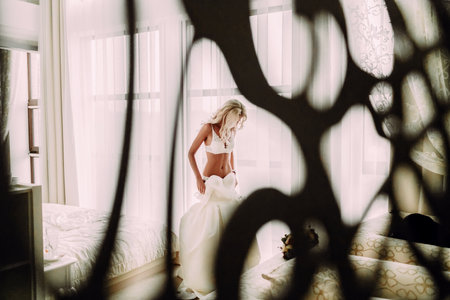 Sexual bride in white lingerie is putting on her white wedding dress.の写真素材