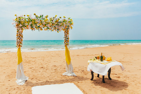 Wedding arch decorated with flowers on a tropical sand beach. Outdoor beach wedding setupの写真素材