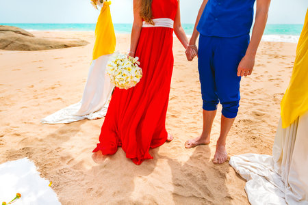A picture of a happy couple holding hands at the beach. Newlyweds at the honeymoon. Close-upの写真素材