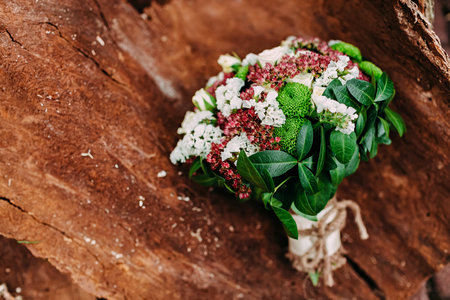 Rustic wedding bouquet with different flowers and greens on wooden backgroundの写真素材