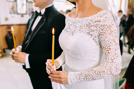 Unrecognizable bride and groom in the church during the Christian wedding ceremony. Close-up imageの写真素材