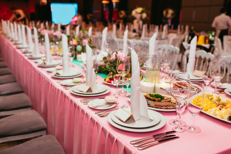 Long festive table served dishes and decorated with branches of greenery. Wedding banquet. Indoorの写真素材