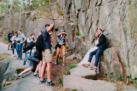 A group of paparazzi people taking pictures of a wedding couple man in nature. Selective soft focus...