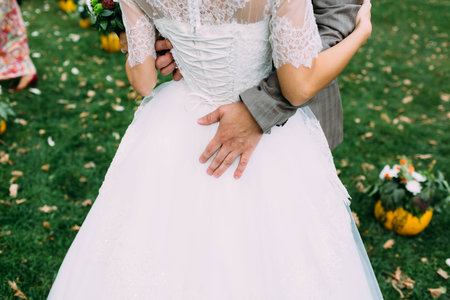 Groom embracing his bride by her waist. Wedding concept. Artwork. Close-upの写真素材