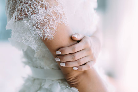 Elegant bride's hand with a white lace veil. Artwork Wedding concept. Close-up image, soft focus