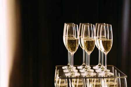 Champagne glasses standing in a tower at the party on a dark background. Artwork. Copy space for textの写真素材