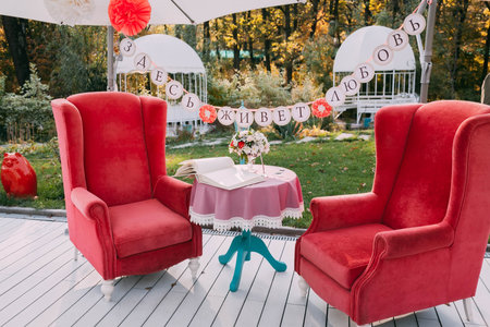 Wedding. The inscription in Russian "love lives here ". Rest area decorated with red armchairs and flowers composition on ceremony place. Relax zoneの写真素材