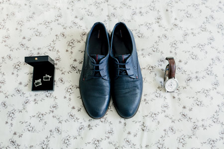 Grooms shoes and cufflinks, a wristwatch on a light background. Wedding concept. Artwork, soft focusの写真素材