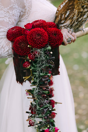 Bouquet with bordeaux dahlias on bride hand. Wedding decoration. Flowers dahlias. Close-up.の写真素材